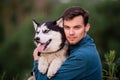 Portrait of a handsome young man and his pet dog Siberian Husky in nature Royalty Free Stock Photo