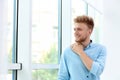 Portrait of handsome young man looking out window Royalty Free Stock Photo