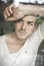 Portrait of handsome young man looking through window