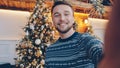 Portrait of handsome young man making online video call on Christmas day talking holding camera Royalty Free Stock Photo