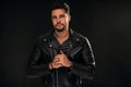 Portrait of a handsome young man with manly face. Male beauty. Fashionable brunet guy in black leather jacket looking at the Royalty Free Stock Photo