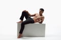 Portrait of handsome young man with muscular fit body posing shirtless in trousers against white studio background. Body Royalty Free Stock Photo
