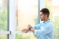 Portrait of handsome young man  out window indoors Royalty Free Stock Photo