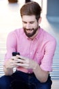 Handsome young man sitting outside looking at mobile phone Royalty Free Stock Photo