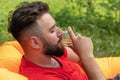 Portrait of handsome young man smelling wine in his glass and keeping eyes closed while relaxing outdoor Royalty Free Stock Photo