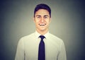 Handsome young man smiling on gray background