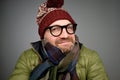 Portrait of a handsome young man smiling wearing warm winter coat, scarf, and funny hat Royalty Free Stock Photo