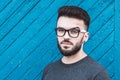 Portrait of a handsome young man standing against blue wooden background. Youth culture. Barbershop Royalty Free Stock Photo