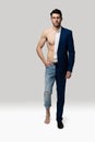 Portrait of a handsome young man in suit and shirtless muscular male model against white background Royalty Free Stock Photo