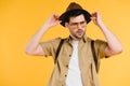 portrait of handsome young man in sunglasses adjusting hat and looking away Royalty Free Stock Photo