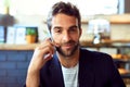 Meet me for coffee. Portrait of a handsome young man talking on a phone in a cafe. Royalty Free Stock Photo