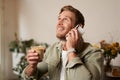 Portrait of handsome young man talking on the phone, sitting in cafe and drinking coffee, answering a call Royalty Free Stock Photo