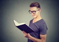 Portrait handsome young man wearing glasses reading a book Royalty Free Stock Photo