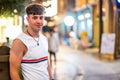 Portrait of handsome young man wearing sleeveless t-shirt looking at camera on city street at night. Royalty Free Stock Photo