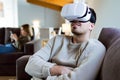 Handsome young smiling man using virtual reality headset at home. Royalty Free Stock Photo