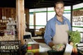 Portrait of handsome young store clerk holding vegetable in supermarket Royalty Free Stock Photo