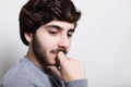 Portrait of handsome young thoughtful man with beard holding hand on chin looking down thinking about something inportant. Pensive Royalty Free Stock Photo