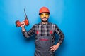 Portrait of bearded handyman with electric drill isolated on blue background Royalty Free Stock Photo