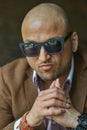 Portrait of a hansome indian businessman wearing sunglasses, serious and confident man looking at camera