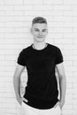 Portrait of hansome young man teen in black t-shirt and white pants on white bricks