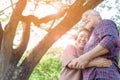 Portrait happiness older couple. Charming grandfather and grandmother is embracing each other with love and smiley faces in a park Royalty Free Stock Photo