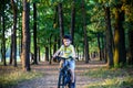 Portrait of happy active teenage boy in safety helmet relaxing after school riding his bike in beautiful park on sunny autumn day Royalty Free Stock Photo