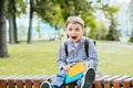 Portrait of happy adorable little kid boy holding different colorful books on first day to school or nursery. Back to Royalty Free Stock Photo