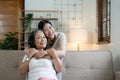 Portrait happy adult daughter and older mother hugging and holding hands, sitting on couch at home, young woman and Royalty Free Stock Photo