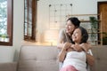 Portrait happy adult daughter and older mother hugging and holding hands, sitting on couch at home, young woman and Royalty Free Stock Photo