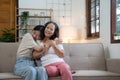 Portrait happy adult daughter and older mother hugging and holding hands, sitting on couch at home, young woman and Royalty Free Stock Photo