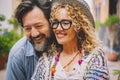 Portrait of happy adult man and woman smiling together in outoor with street in background. Pretty female people with eyewear and