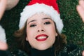 Portrait of a happy adult woman taking a selfie at Christmas in the garden of the park outdoors wearing a Santa hat Royalty Free Stock Photo