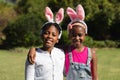 Portrait of happy african american brother and sister embracing wearing bunny ears outdoors Royalty Free Stock Photo