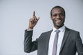 portrait of happy african american businessman pointing up and looking at camera