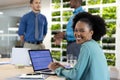 Portrait of happy african american businesswoman with laptop and diverse colleagues in modern office Royalty Free Stock Photo