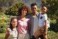 Portrait of happy african american couple with son and daughter outdoors, smiling in sunny garden Royalty Free Stock Photo