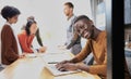 Portrait of a happy African American entrepreneur displaying computer laptop in office Royalty Free Stock Photo