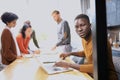 Portrait of a happy African American entrepreneur displaying computer laptop in office Royalty Free Stock Photo