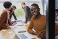 Portrait of a happy African American entrepreneur displaying computer laptop in office Royalty Free Stock Photo