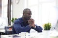 Portrait of a happy African American entrepreneur displaying computer in office. Royalty Free Stock Photo