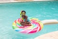 Portrait of happy african american girl with snorkel sitting on inflatable ring in swimming pool Royalty Free Stock Photo