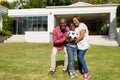 Portrait of happy african american grandparents with grandson holding soccer ball in front yard Royalty Free Stock Photo