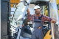 Portrait of a happy African American male worker driving forklift at workplace Royalty Free Stock Photo