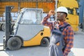 Portrait of a happy African American male worker driving forklift at workplace Royalty Free Stock Photo