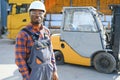 Portrait of a happy African American male worker driving forklift at workplace Royalty Free Stock Photo