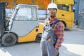 Portrait of a happy African American male worker driving forklift at workplace Royalty Free Stock Photo