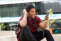 Happy african american man listening to music with mobile phone and earphones Royalty Free Stock Photo