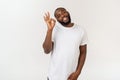 Portrait of happy african-american man showing ok sign and smiling, over white background. Royalty Free Stock Photo