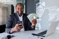 Portrait of a happy African American man sitting in the office at the table with a laptop in front of the camera Royalty Free Stock Photo