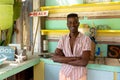 Portrait of happy african american man standing behind counter of surf hire beach shack, copy space Royalty Free Stock Photo